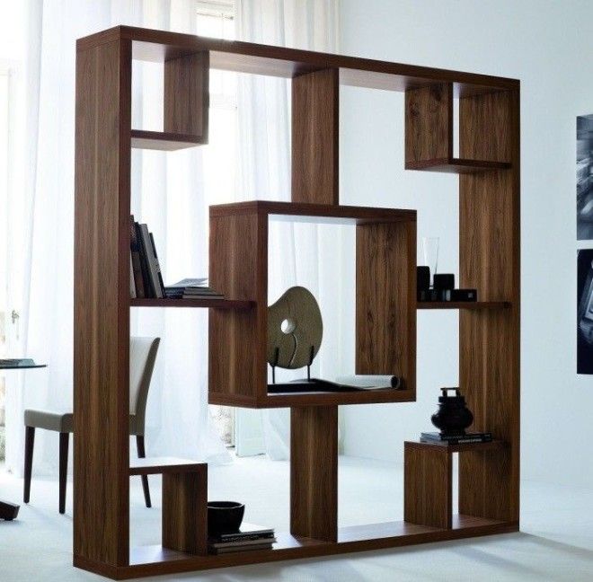 Деревянный стеллаж довольно необычной формы который отделяет рабочую зону от зоны для отдыха