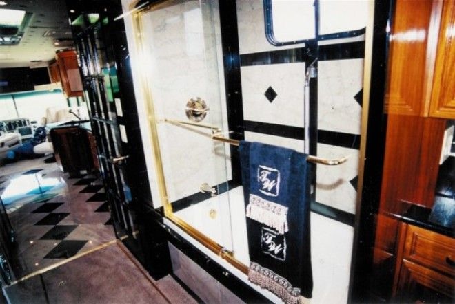 За стеклянной дверью с латунной отделкой находится душевая кабинка Фото camillccom