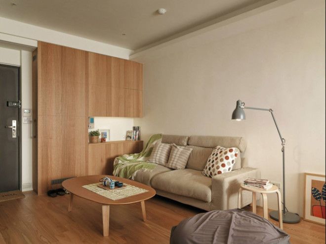 Входная дверь прихожая и гостиная в небольшой двухкомнатной квартире